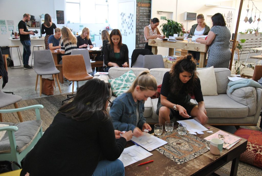Workshop participants journaling and exchanging ideas during a conscious business session.